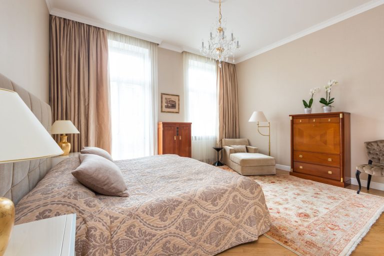 Fitted carpet in a Missouri bedroom with an upholstered headboard and bedside lamps