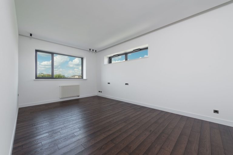 Dark grey laminate flooring in an empty Missouri room with clerestory windows