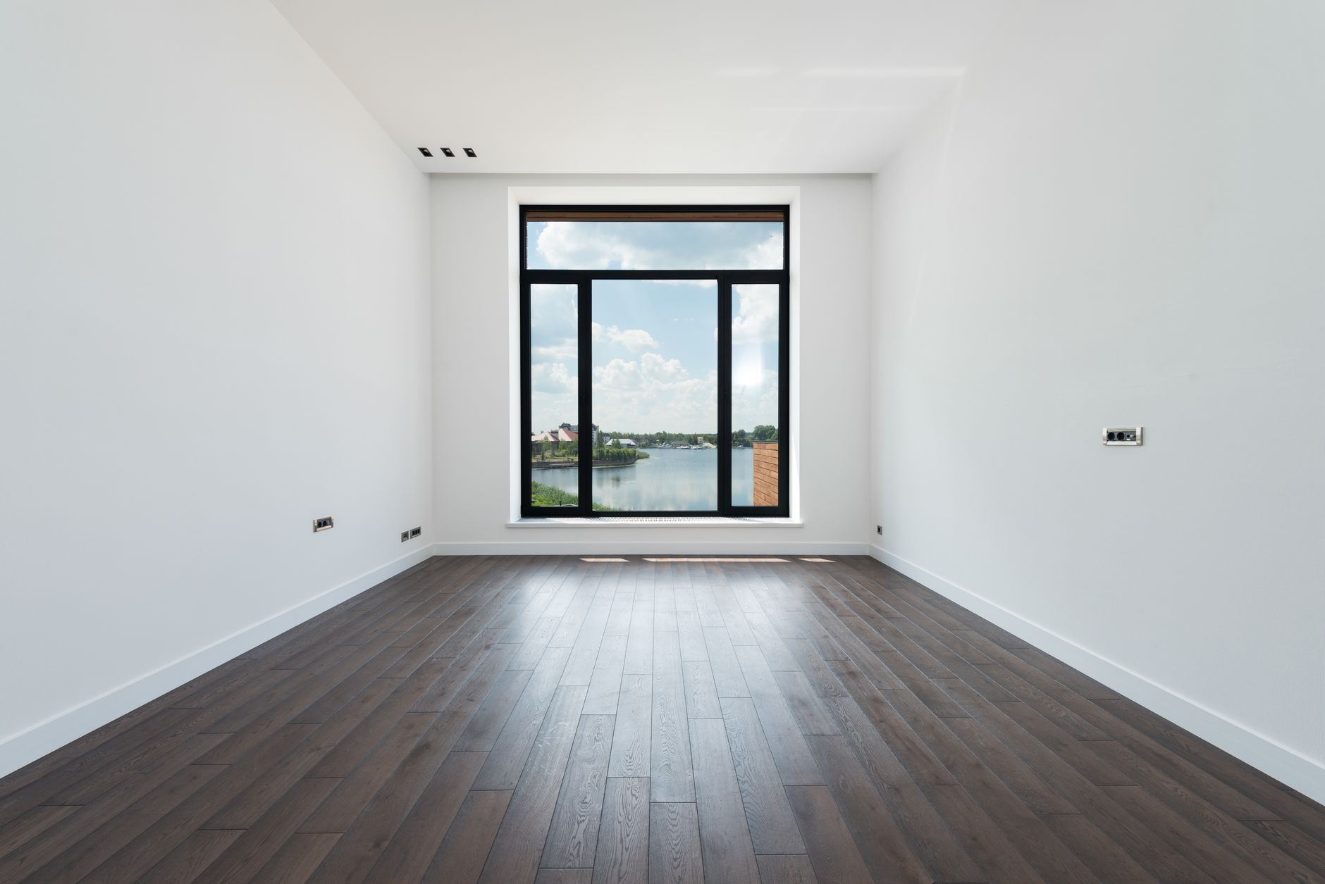 Grey luxury vinyl plank flooring in a bright empty Missouri room with a full-height window
