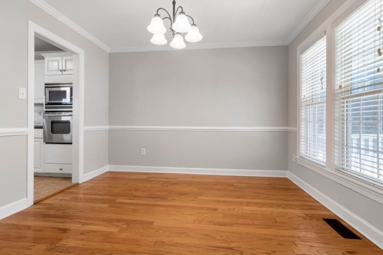 Golden refinished oak flooring in an empty Missouri room with white walls and trim