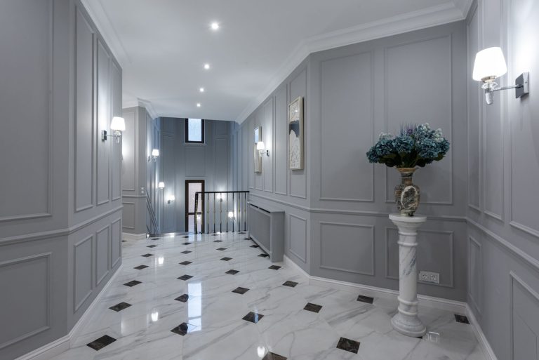 Polished marble flooring in a Missouri hallway with panelled grey walls