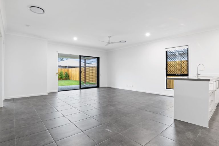 Large-format grey tile flooring in a bright Missouri living room with sliding doors to the garden