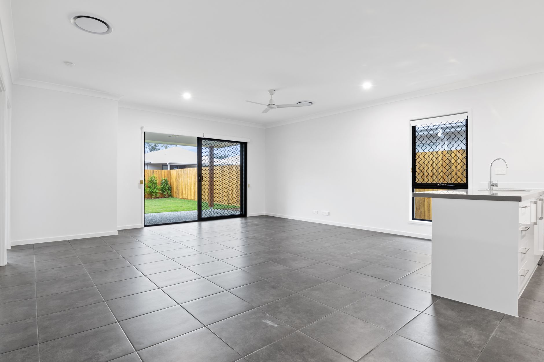 Large-format grey tile flooring in a bright Missouri living room with sliding doors to the garden
