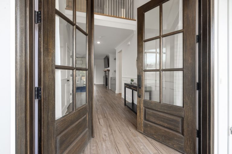 Wide-plank flooring in the entry of a Missouri home, front doors open onto the foyer