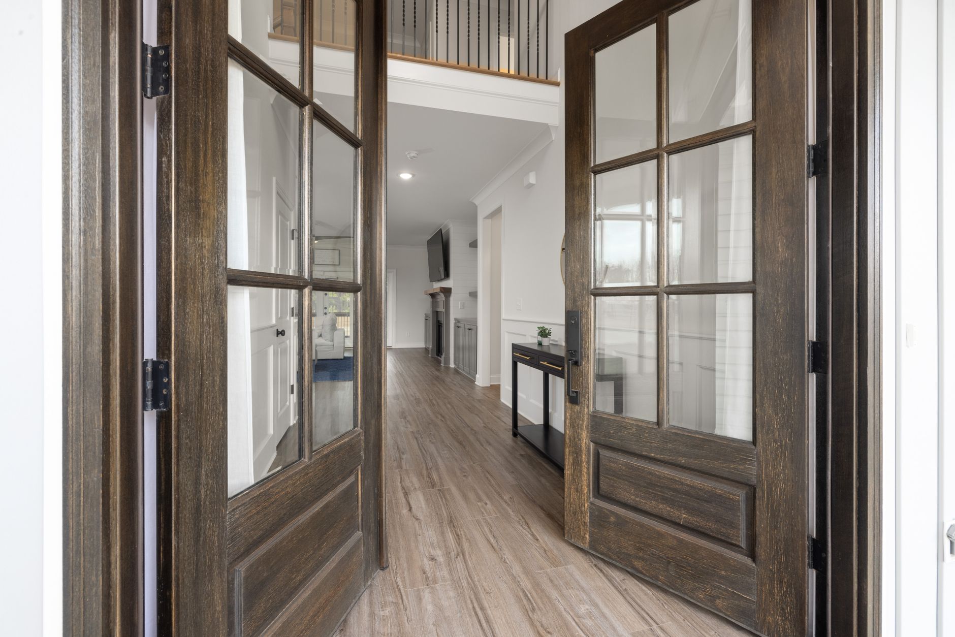 Wide-plank flooring in the entry of a Missouri home, front doors open onto the foyer