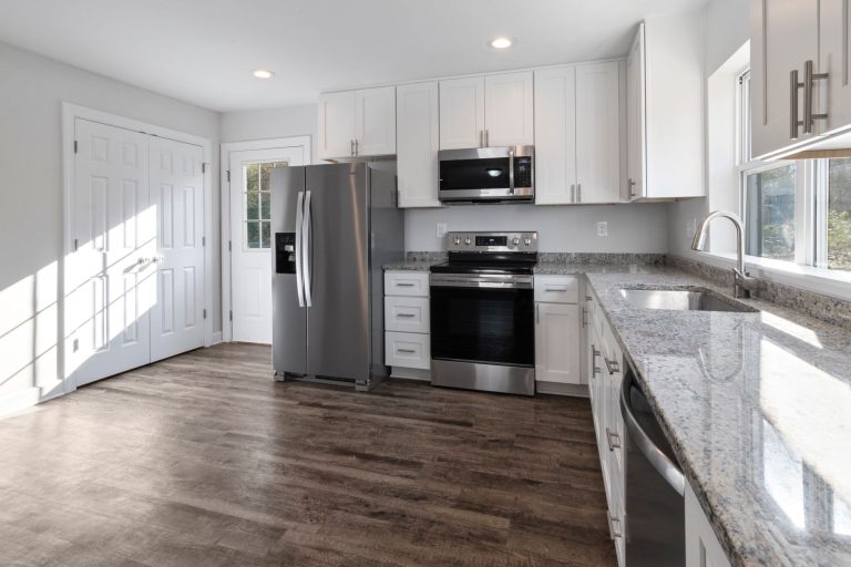 Wood-look plank flooring in a modern Missouri kitchen with stainless appliances and granite counters