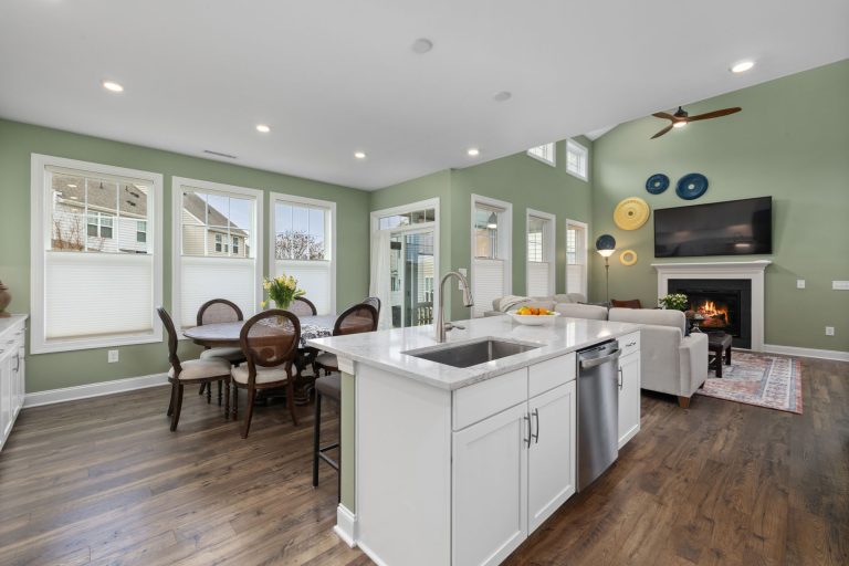 Hardwood flooring running through an open Missouri living room to the kitchen island and fireplace